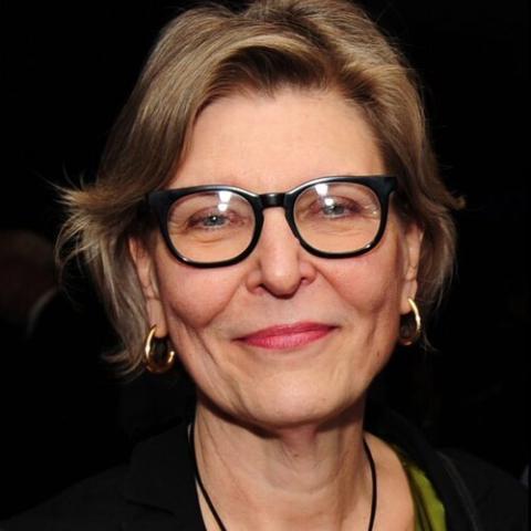 A woman with short blond hair and black framed glasses 